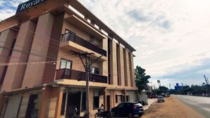 Un hotel llamado 'Royal Stay' con una estructura de varios pisos, balcones y una entrada visible.