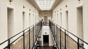 A corridor with a skylight, wooden flooring, and a central staircase.