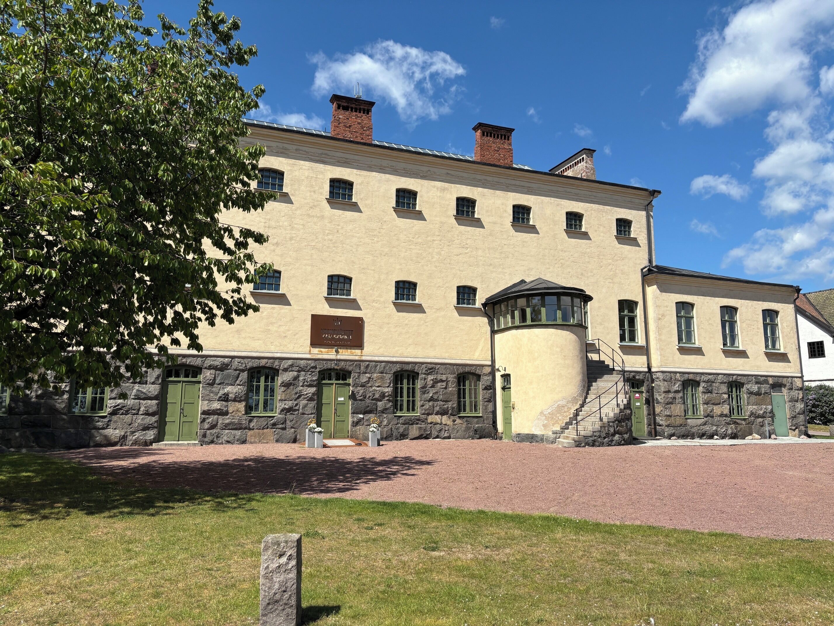 A historic building with a stone facade, multiple windows, and a central turret.