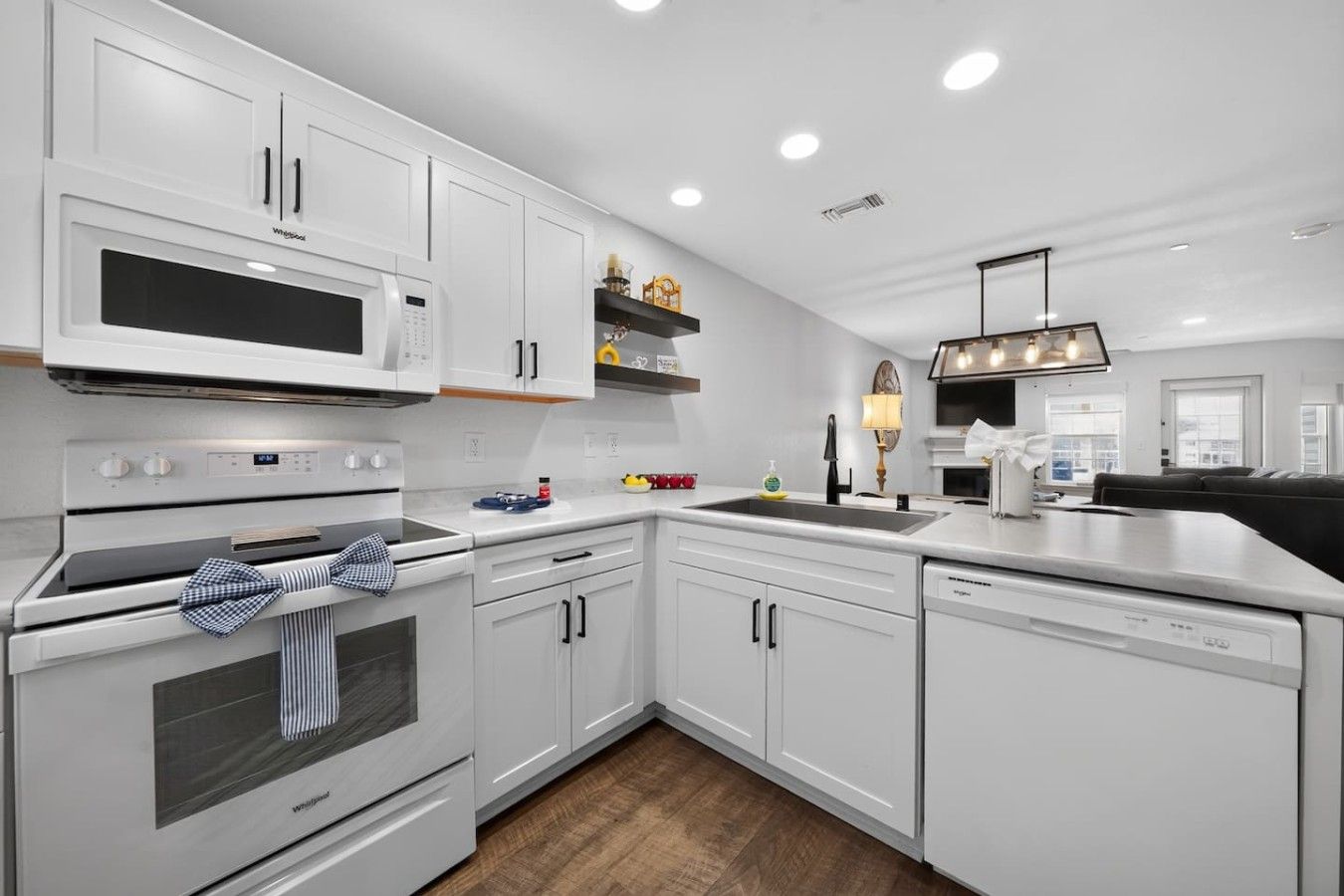 A modern kitchen with white cabinetry, a built-in microwave, and a dishwasher.