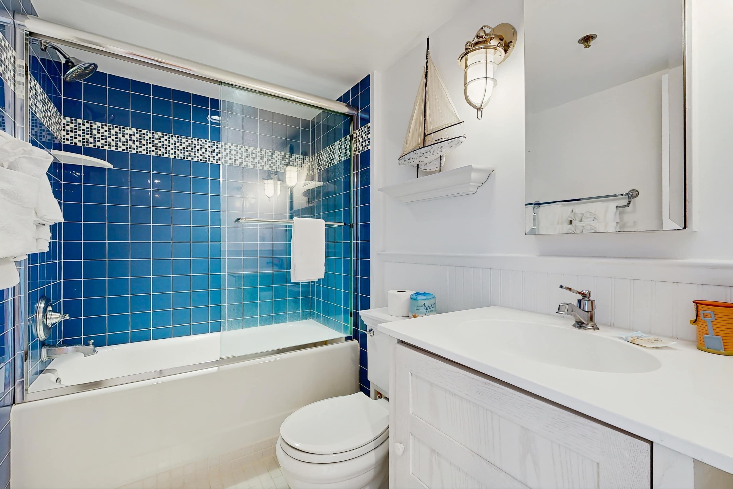 A bathroom with a bathtub, toilet, and sink.