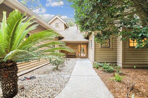 A pathway leading to a house with a sloped roof and a door. - Beautiful Home w/ Private Pool & Spa (Hilton Head Island)