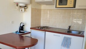 A compact kitchen with a microwave, stove, and coffee maker. - STUDIO 30 M FROM THE BEACH AND NEAR SHOPS AND BUS STOPS (Sète)