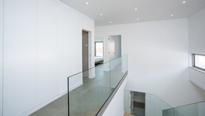 A modern interior with a glass railing, a staircase, and a view of a bedroom. - Bazaruto T4 swimingpool Lagos (Lagos)