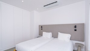 A modern hotel room with a double bed, a bedside table, a small round table, and a wardrobe. - Bazaruto T4 swimingpool Lagos (Lagos)