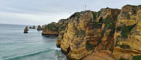 Un paisaje costero con acantilados, una playa de arena y el océano.
