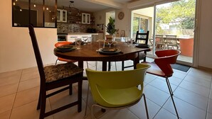 A dining area with a round table, chairs, and hanging light fixtures. - Villa Nectar ~ Garden ~ Parking ~ Air Conditioning (Beauzelle)
