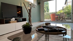 A modern living room with a flat-screen TV, a glass coffee table, and a potted plant. - Villa Nectar ~ Garden ~ Parking ~ Air Conditioning (Beauzelle)