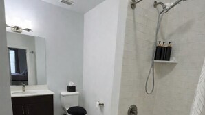 Un bany modern amb vàter, rentamig i zona de dutxa.