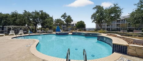 Piscina com borda azulejada, posto de salva-vidas e placa de proibição de saltos.