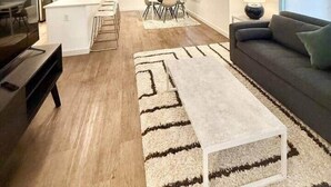 Una sala moderna con sofá, mesa de centro y un comedor con sillas y una mesa.