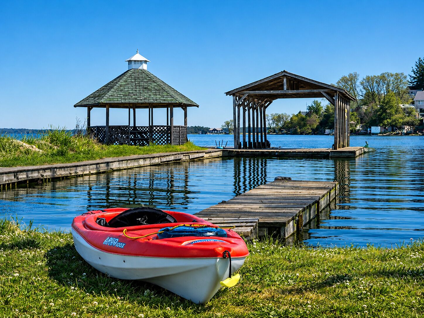 A calm lake with a gazebo and a dock.