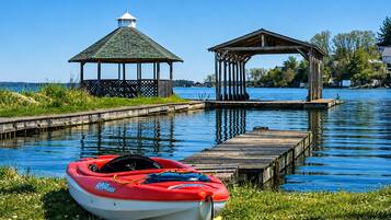 A calm lake with a gazebo and a dock.