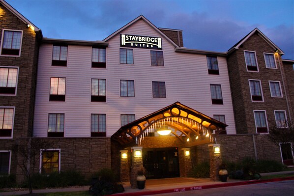 Um hotel Staybridge Suites com fachada de tijolos, várias janelas e entrada coberta.