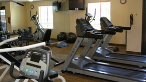 A gym with treadmills, a stationary bike, and free weights.