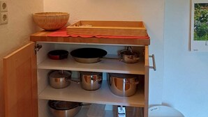 Eine Küche mit Holzböden, Edelstahlkochgeschirr und einer weißen Mülltonne.