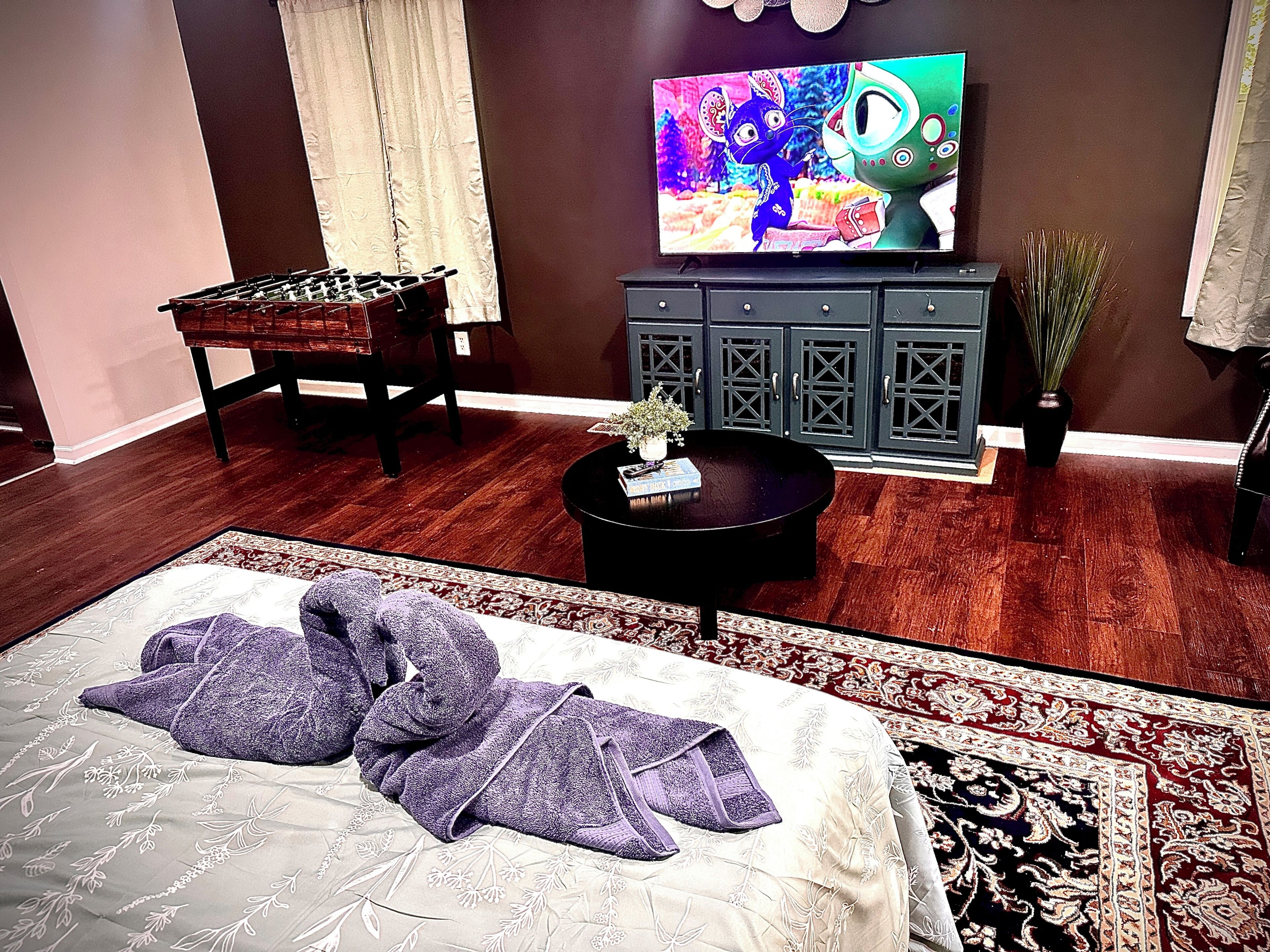 Una habitación con cama, sofá, televisión, armario y una mesita.