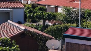 A residential area with red-tiled roofs, palm trees, and a clear blue sky. - Studio apartment in a residential complex on the edge of a pond (Le Barcarès)