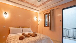 A bedroom with a bed, pillows, a blanket, and rolled towels. - Riad 3ch Salon, Terrasse avec Jacuzzi ,à Jemaa El Fna (Marrakech)