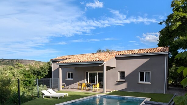 A modern house with a swimming pool, a patio with chairs, and a view of the surrounding landscape. - Villa 'Des Rives Et Chevaux 07' with Private Pool, Wi-Fi and Air Conditioning (Montréal)