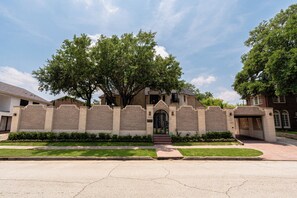 Una casa residencial con fachada de ladrillo, una entrada principal con escalones y un camino de acceso.