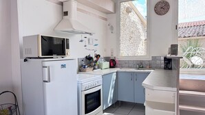 A kitchen with a microwave, oven, and sink. - Maison de la Sau (Saint-Georges-d'Oléron)