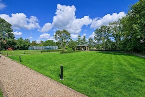 A well-maintained lawn with a gazebo, a greenhouse, and a gravel path. - Elegy House (Slough)