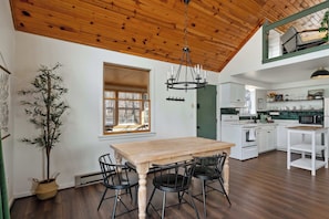 Un comedor con una mesa y sillas de madera, un candelabro y una planta en maceta.