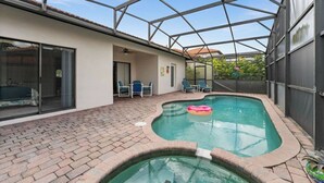 Piscina coberta com um pátio de tijolos, uma porta de vidro que dá para um quarto e uma estrutura de telhado metálico.