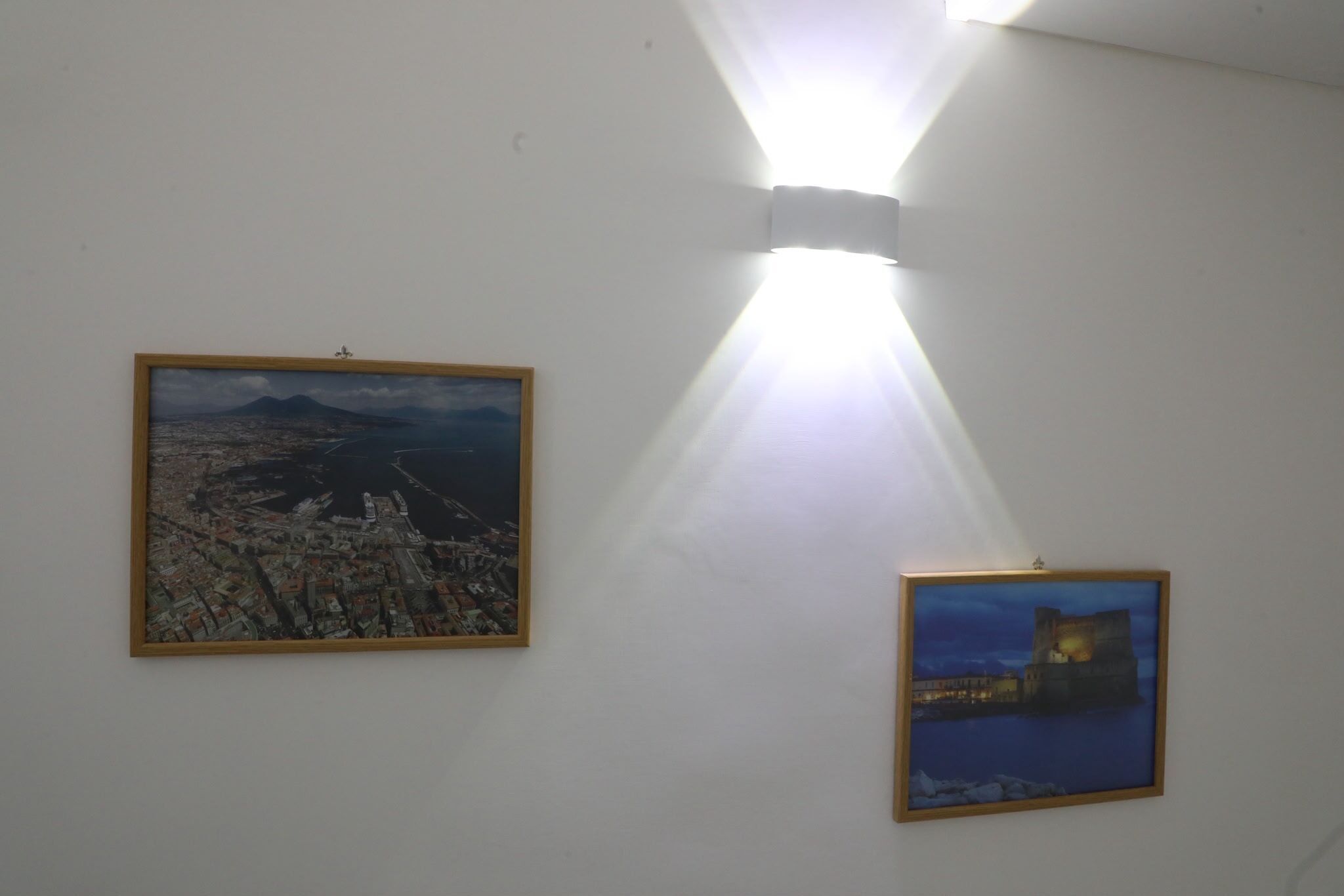 Two framed artworks on a wall with a spotlight.