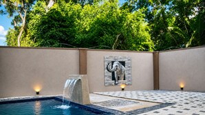 A pool area with a waterfall feature, a tiled deck, and a wall-mounted elephant sculpture. -  Araliya Villa- Luxury 3-Bedrooms, Private Pool & Sea Views. Breakfast Included. (Rekawa Road)
