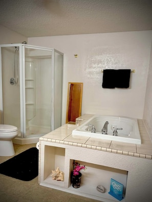 Ein Badezimmer mit Dusche, Toilette und Badewanne.