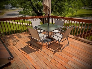 Eine Holzterrasse mit Tisch und Stühlen, umgeben von einer Holzbrüstung.