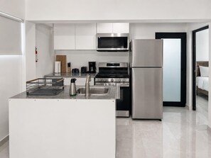 A modern kitchen with stainless steel appliances, a built-in oven, and a microwave.