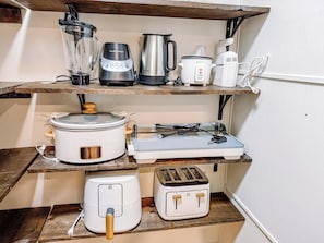 Une cuisine équipée d’un mixeur, d’une machine à café, d’une mijoteuse, d’un grille-pain et d’une balance.