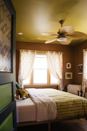 A bedroom with a bed, a ceiling fan, curtains, and a window. - Casa Lita – Colorful Historic Home in the Railyard (Santa Fe)
