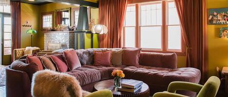 A cozy living room with a sectional sofa, a coffee table, and a green armchair.