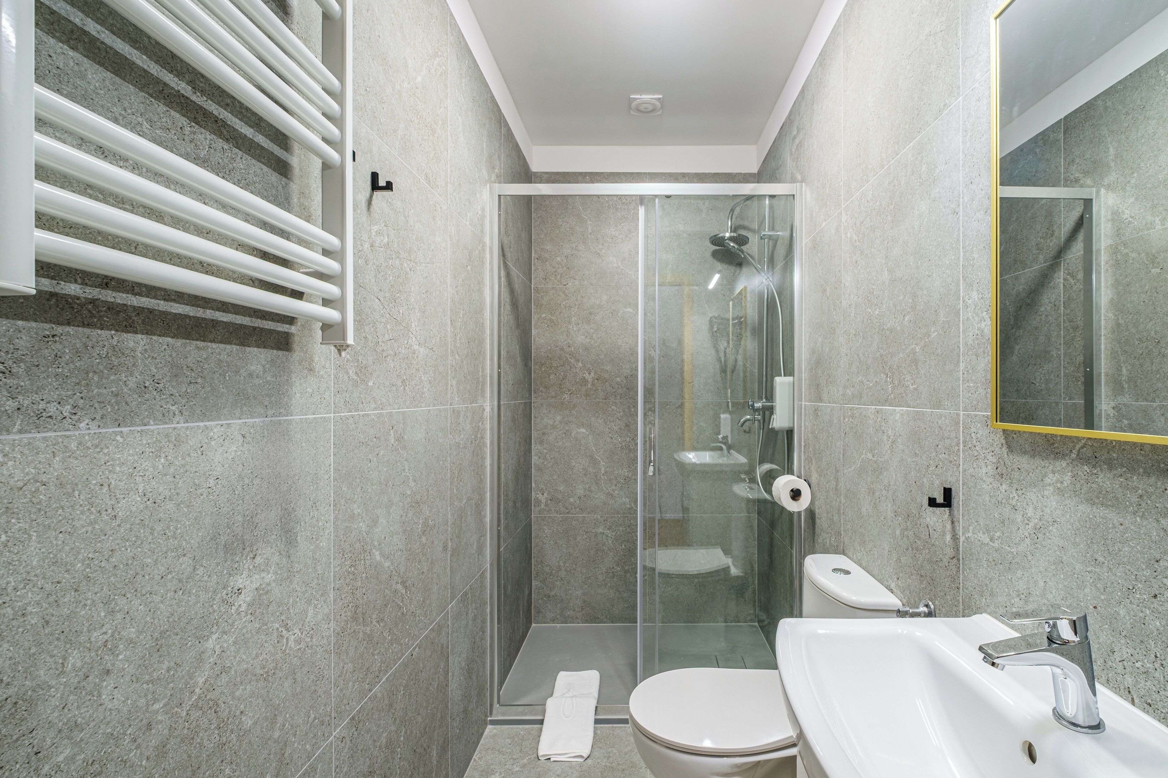 Une salle de bain moderne avec une douche à parois de verre, des toilettes et un lavabo.
