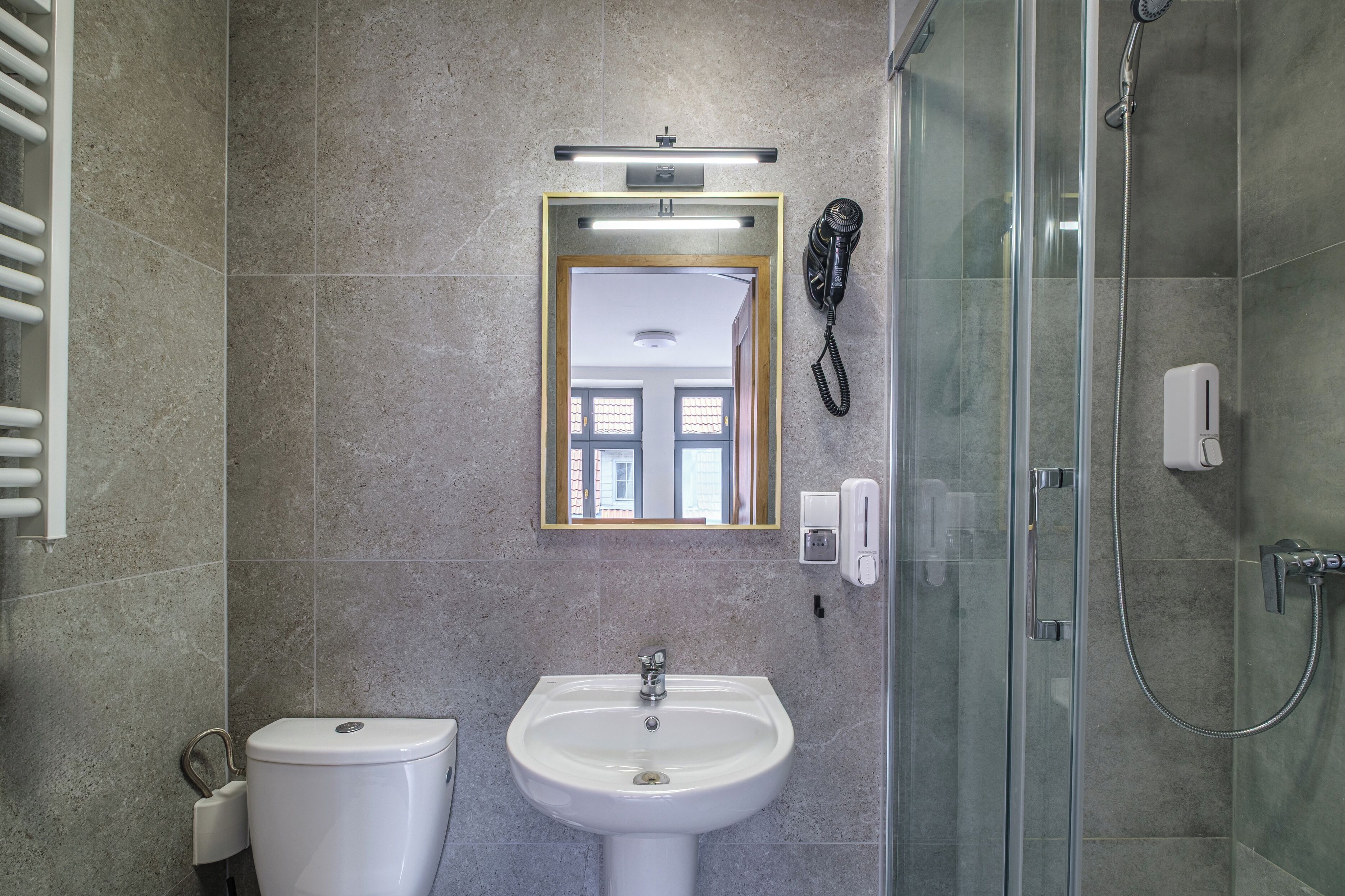 Une salle de bain équipée de toilettes, d’un lavabo et d’une douche à parois en verre.