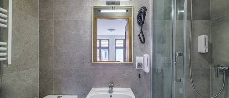 Un bagno con il water, un lavandino e una cabina doccia in vetro.