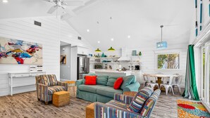 Una sala moderna con un conjunto de sofás, una mesa de comedor y una zona de cocina.