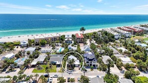 Un complejo turístico costero con varias edificaciones, una playa y una vista despejada del océano.