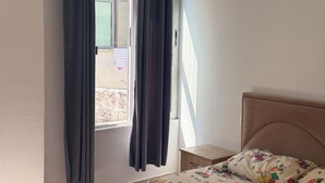 Una camera da letto con un letto, tende, una finestra e vista sull'esterno.