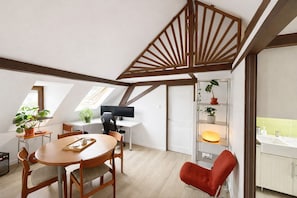 A loft-style room with a dining area, a workspace, and a bathroom. - The Gentle Haven: Cosy Apartment in Strasbourg (Strasbourg)
