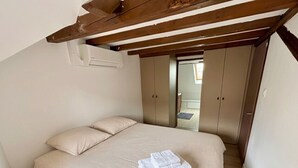 Un dormitorio con una cama, techo de madera y un armario.