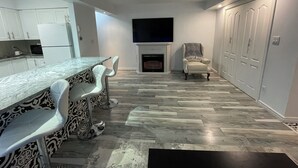 A modern kitchen with white cabinets, a marble countertop, and a built-in TV. - Spacious newly renovated two bedroom apartment (Sault Ste. Marie)