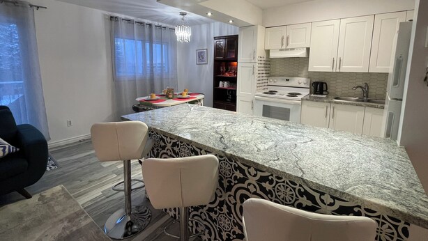 A modern kitchen with white cabinets, a marble countertop, and a gas stove. - Spacious newly renovated two bedroom apartment (Sault Ste. Marie)