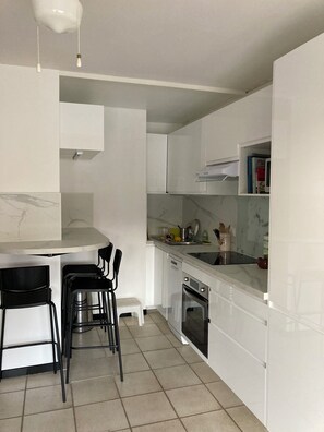 A modern kitchen with white cabinets, a marble countertop, a built-in oven, and a sink. - Giens Les Canotiers Peninsula, apartment with ocean view, La Bergerie Beach (Hyeres)