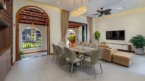 Ein modernes Wohnzimmer mit Essbereich, einem Fernseher und einem Deckenventilator.
