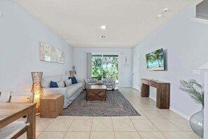 Ein modernes Wohnzimmer mit Sofa, Couchtisch und einem Gemälde an der Wand.